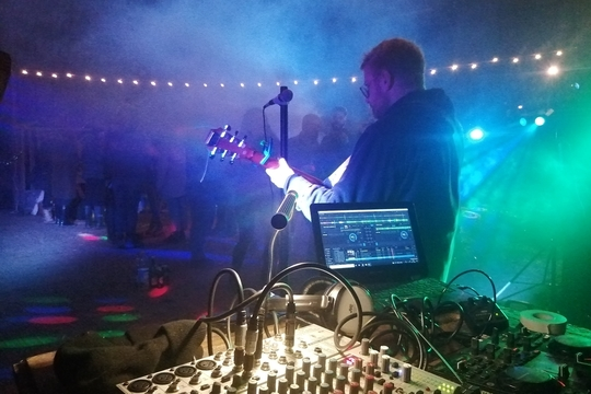 Image of music equipment and a man playing a guitar.