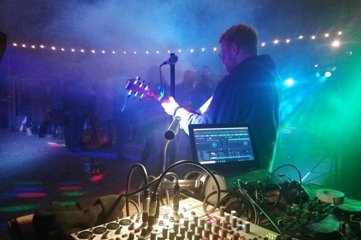 Image of music equipment and a man playing a guitar.